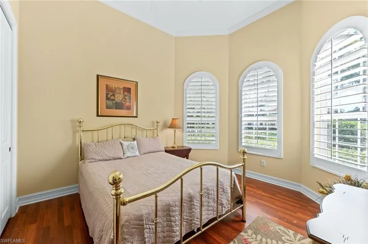 Bedroom featuring wood flooring, ornamental molding, and a closet
