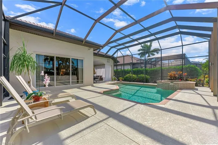 Integrated pool / spa featuring a screened in patio