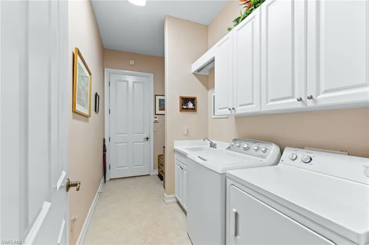 Laundry area featuring cabinet space, separate washer and dryer, and light tile patterned floors