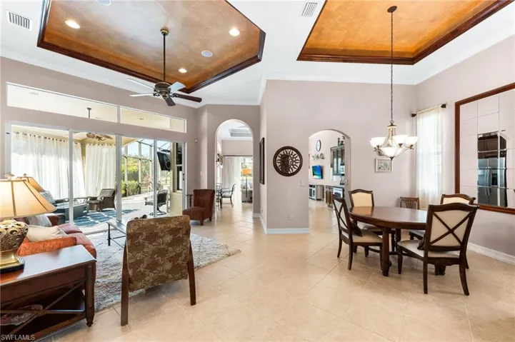 Dining space featuring arched walkways, plenty of natural light, crown molding, a ceiling fan, and recessed lighting