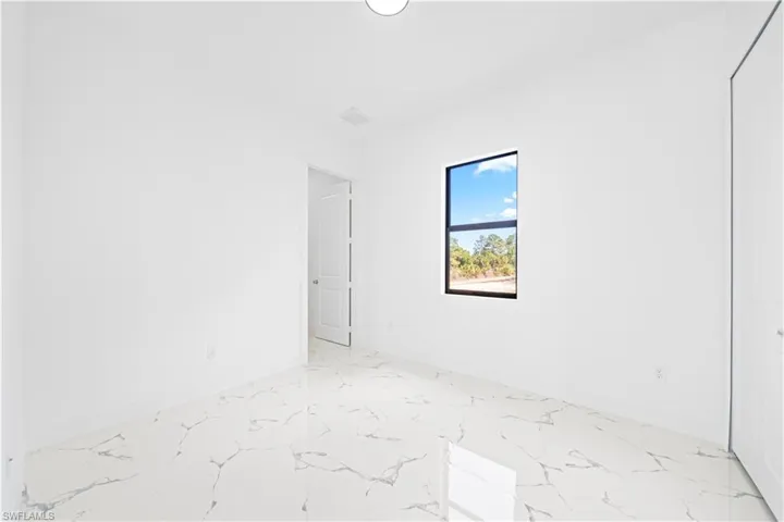 Empty room featuring baseboards and light marble finish floors
