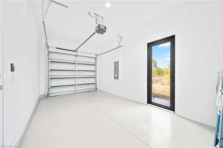 Garage featuring electric panel and a garage door opener