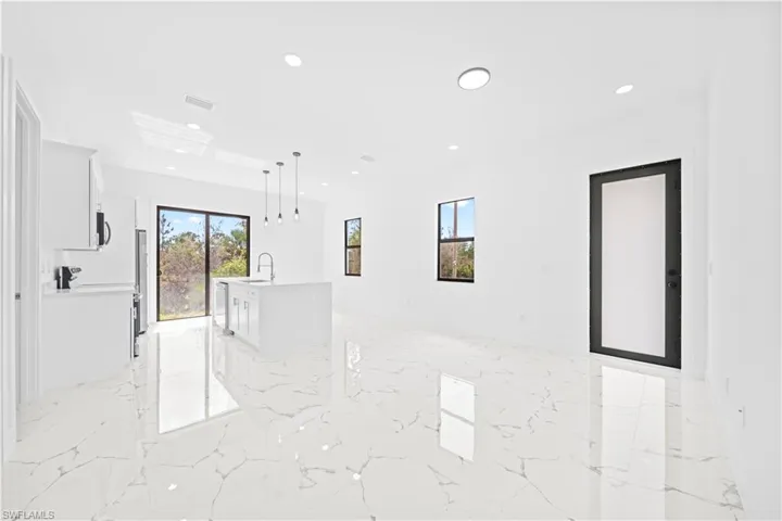 Empty room featuring light marble finish floors and recessed lighting