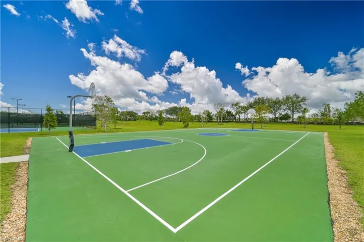 View of basketball court featuring a lawn