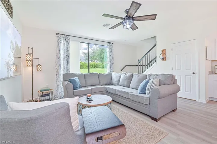 Living room with light hardwood / wood-style floors and ceiling fan