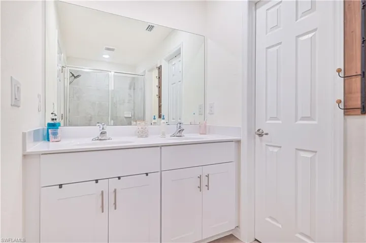 Bathroom featuring vanity and a shower with shower door