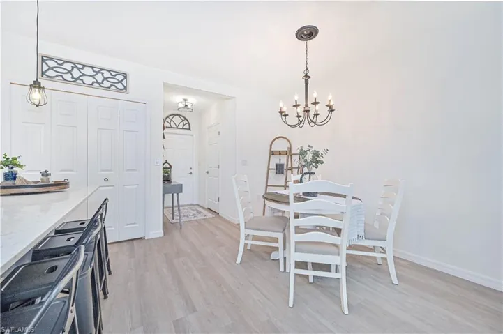 Dining area featuring light wood-type flooring and an inviting chandelier