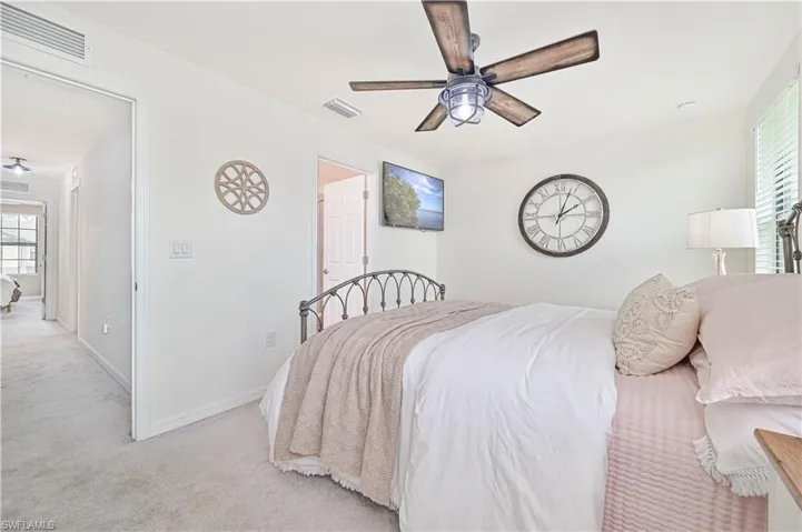 Bedroom with ceiling fan and light carpet