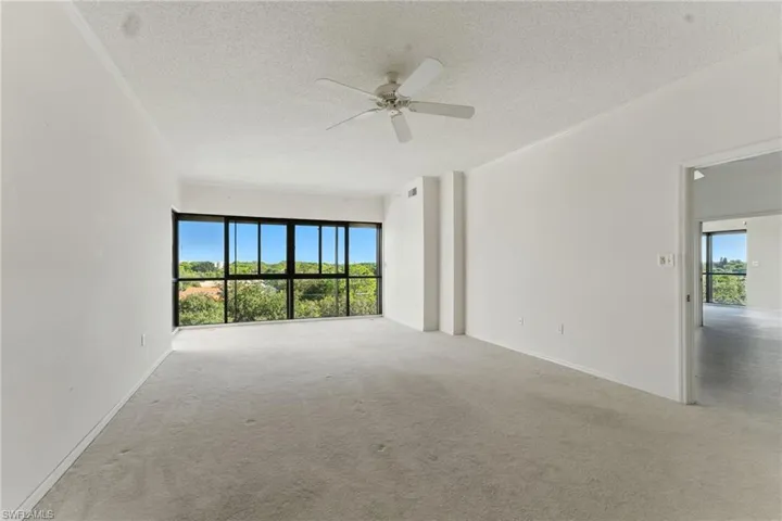 Carpeted empty room with a textured ceiling and a ceiling fan