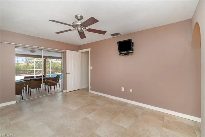 Primary Bedroom with sliding glass doors to the back screen enclosure.