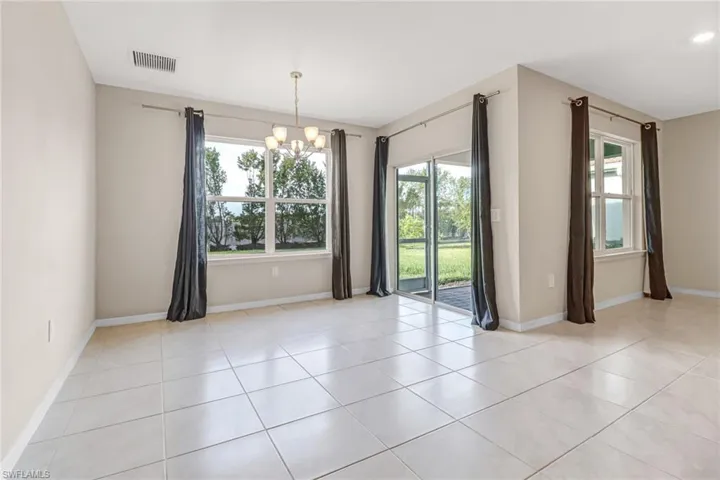 Tiled empty room with an inviting chandelier