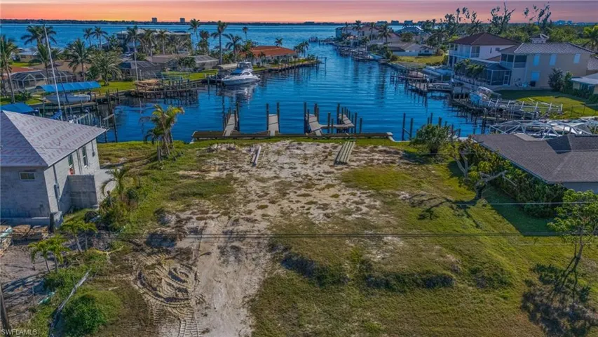 Aerial view at dusk featuring a water view