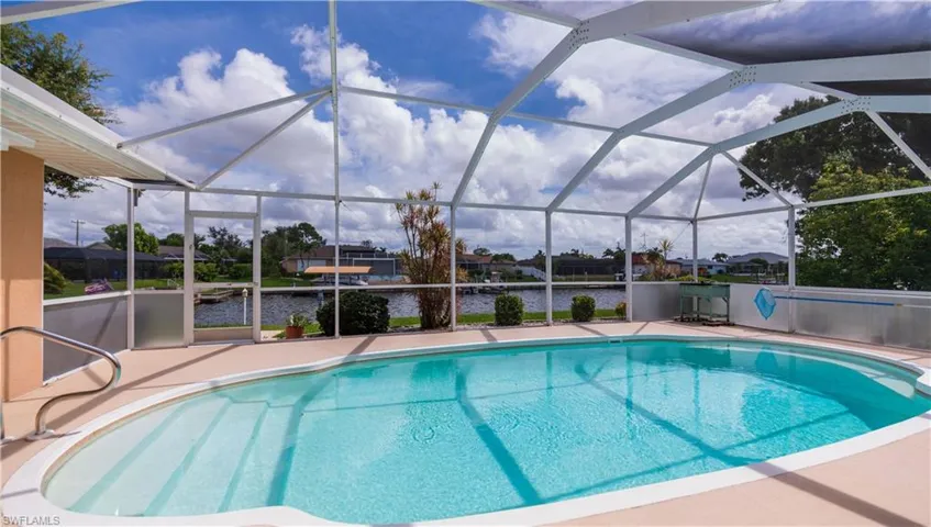 View of swimming pool featuring a screened lanai