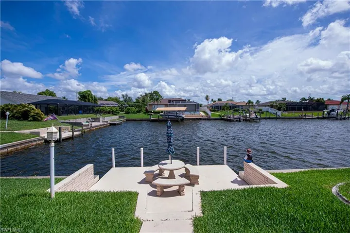 View of dock with a yard, and a water view