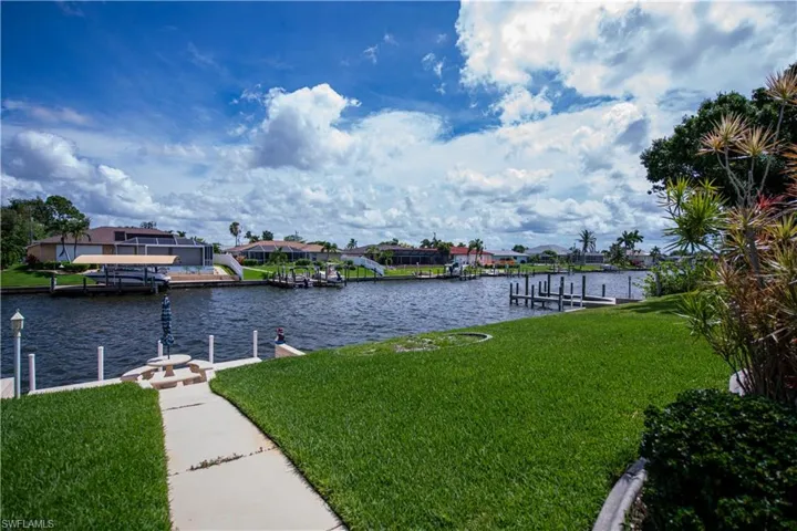 Dock area with a lawn and a water view