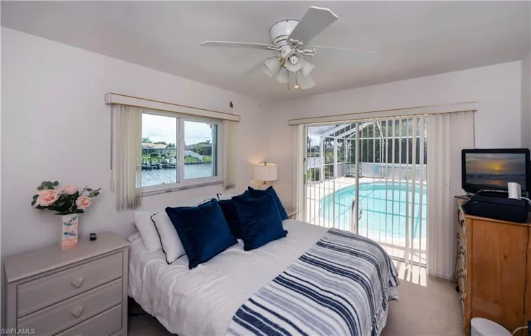 Guest bedroom featuring carpet, ceiling fan, and access to screened pool area