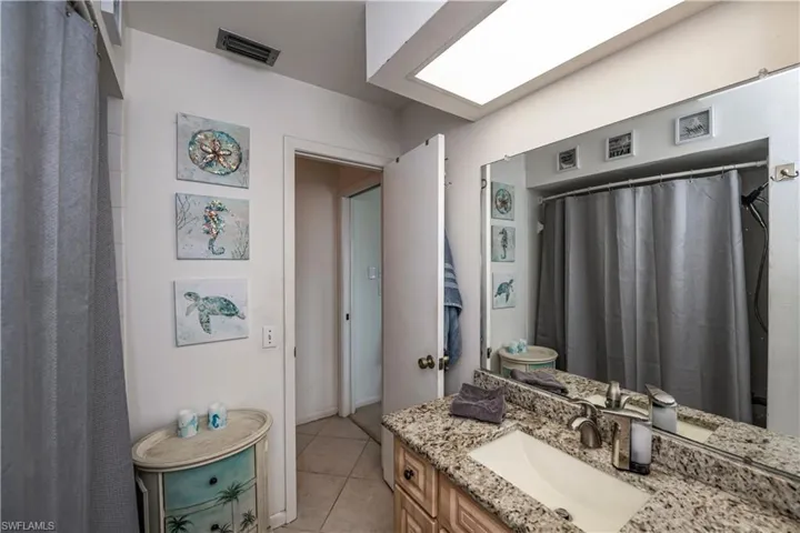 Bathroom featuring tile flooring and vanity with pool access