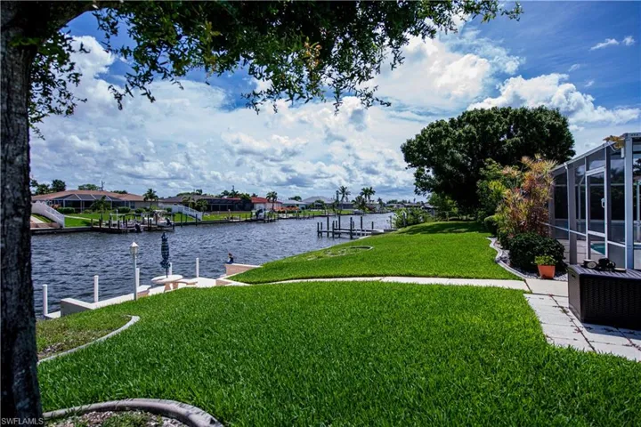 View of yard featuring a dock, a lanai, and a water view
