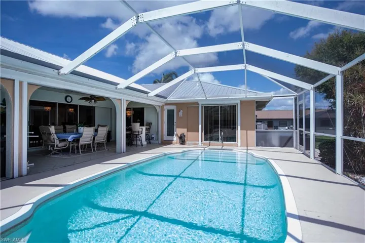 View of pool with ceiling fan, a lanai, and a patio