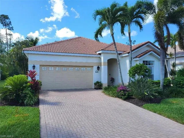 Mediterranean / spanish-style home with a tiled roof, stucco siding, an attached garage, and decorative driveway