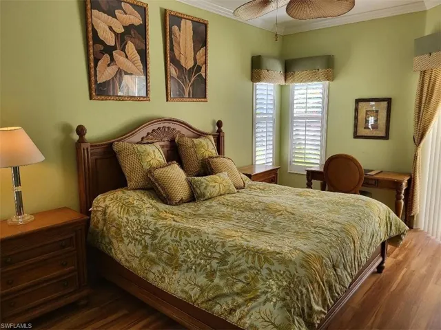 Bedroom featuring ornamental molding, wood finished floors, and ceiling fan