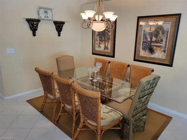 Dining area with light tile patterned floors and a chandelier