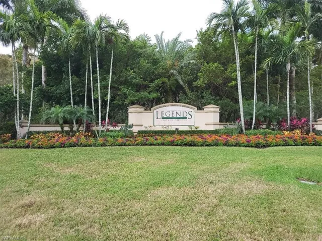 Community sign with a yard and a forest view