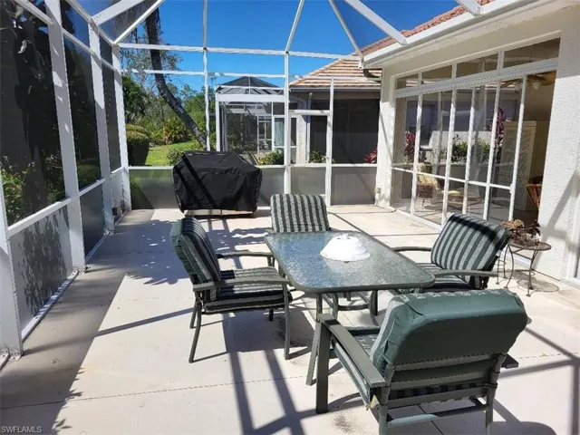 View of patio with a sunroom, a grill, a lanai, and outdoor dining space