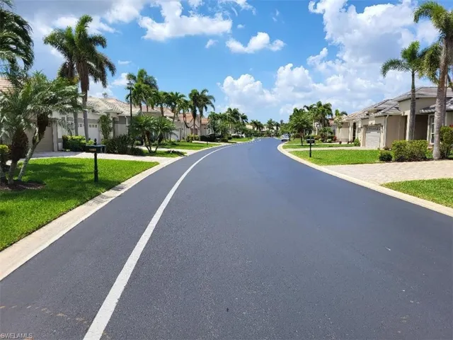 Street view of asphalt road and neighborhood.
