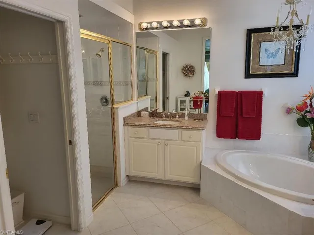 Bathroom with a shower stall, a bath, vanity, and light tile patterned floors