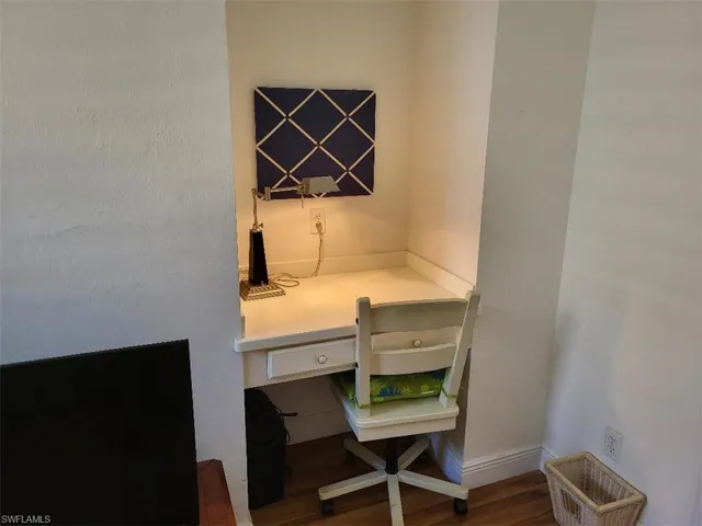 Office area featuring built in study area and dark wood-type flooring.