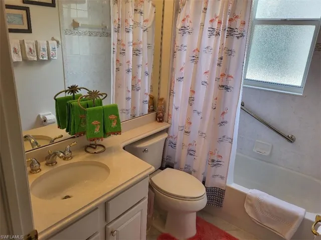 Full bath with vanity, shower / bath combo, and tile patterned flooring