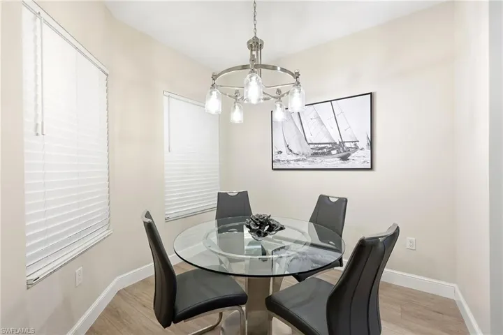 Dining room with light wood-style floors and a chandelier