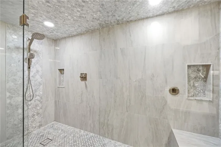 Bathroom with tiled shower and recessed lighting