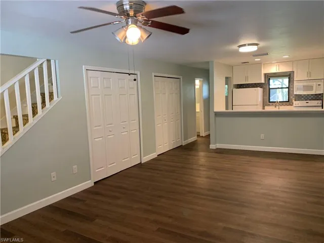 Living room featuring ceiling fan, dark hardwood / wood-style flooring, and sink