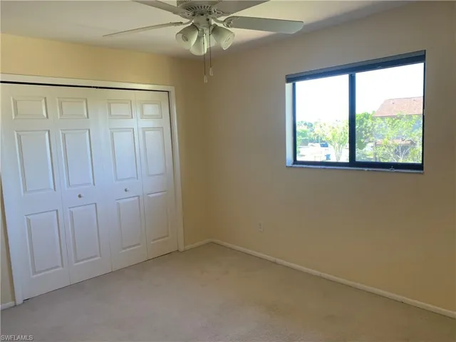 Master bedroom featuring ceiling fan, a closet, and light colored carpet
