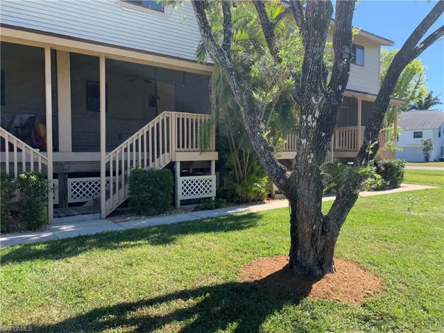 View of property exterior with a lawn and ceiling fan