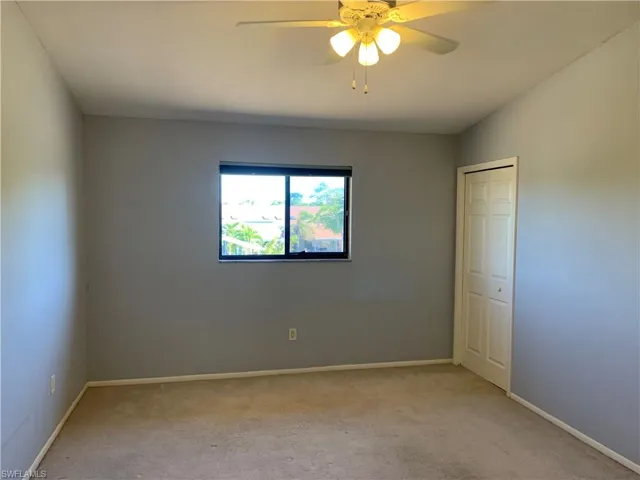 Carpeted bedroom featuring ceiling fan