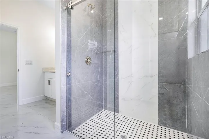 Bathroom featuring vanity and a tile shower
