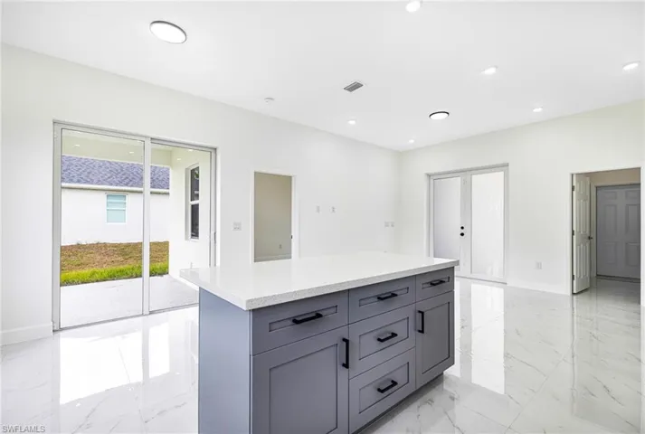 Kitchen with gray cabinets, a kitchen island, and french doors