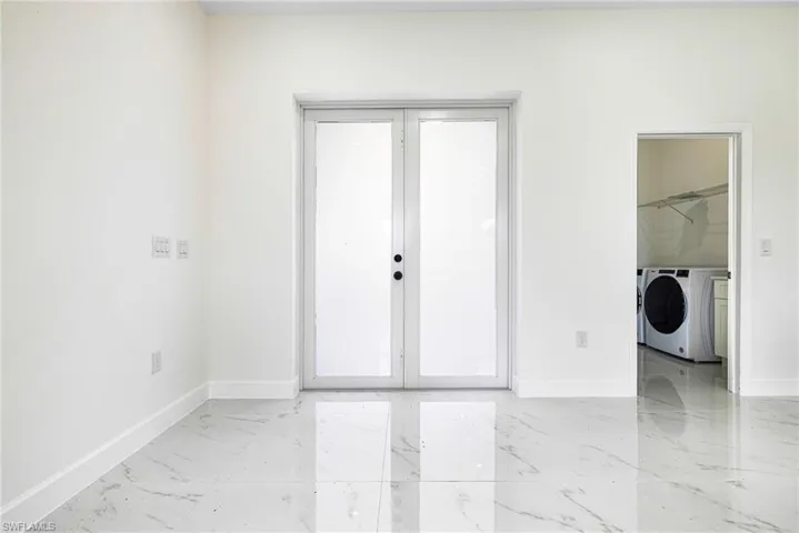 Empty room with french doors and washer and dryer