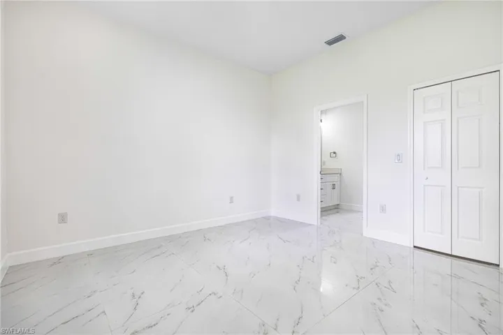 Unfurnished bedroom with connected bathroom and a closet