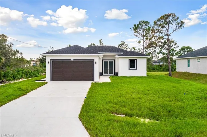 View of front of home with a front yard and a garage