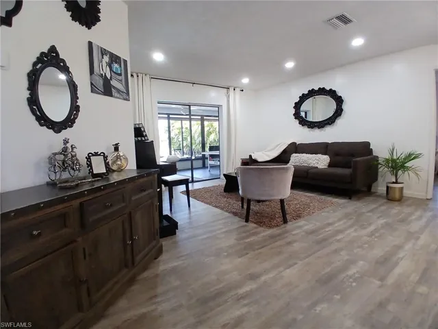 Spacious interior featuring wide plank wood-finish flooring and recessed ceiling lights