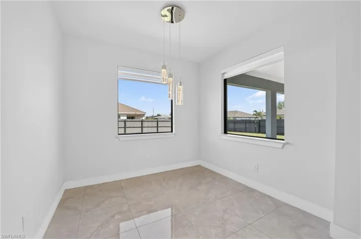 Unfurnished dining area with suspended lighting and light tile patterned floors