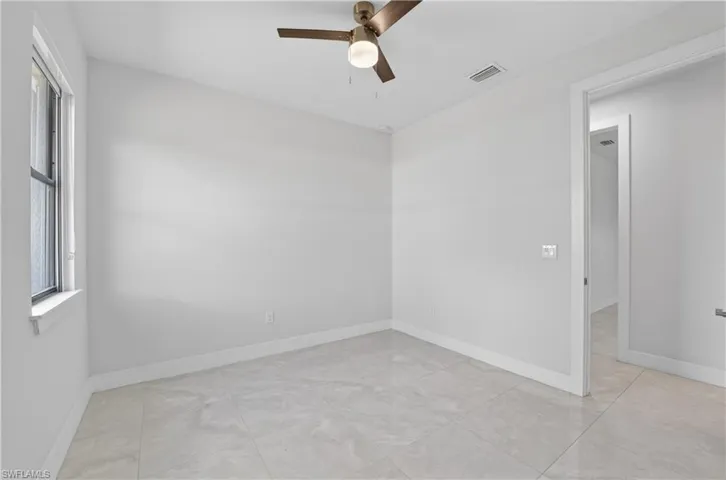 Spare room featuring a ceiling fan and baseboards