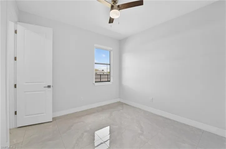 Unfurnished room with baseboards and a ceiling fan