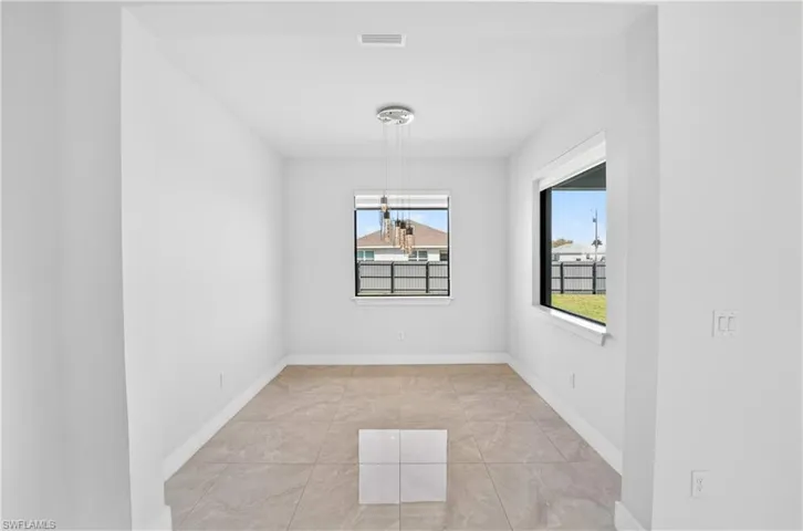 Unfurnished dining area with a chandelier and light tile patterned floors