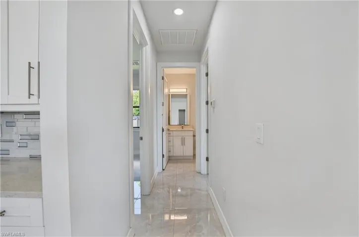 Hallway with light marble finish flooring and recessed lighting
