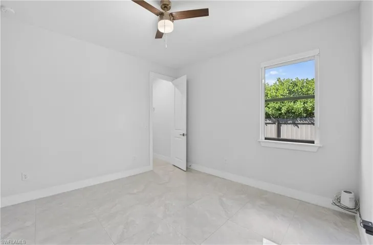 Unfurnished room with baseboards and a ceiling fan